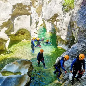 Progression d'un groupe dans les eaux limpides du canyon du Riolan dans la vallée de l'Estéron - Les Geckos